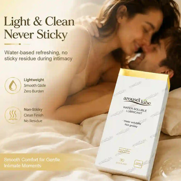A package of arousellube water soluble lubricant is shown in the foreground against a background of a couple embracing in bed. The package is white with a yellow top band and black text.