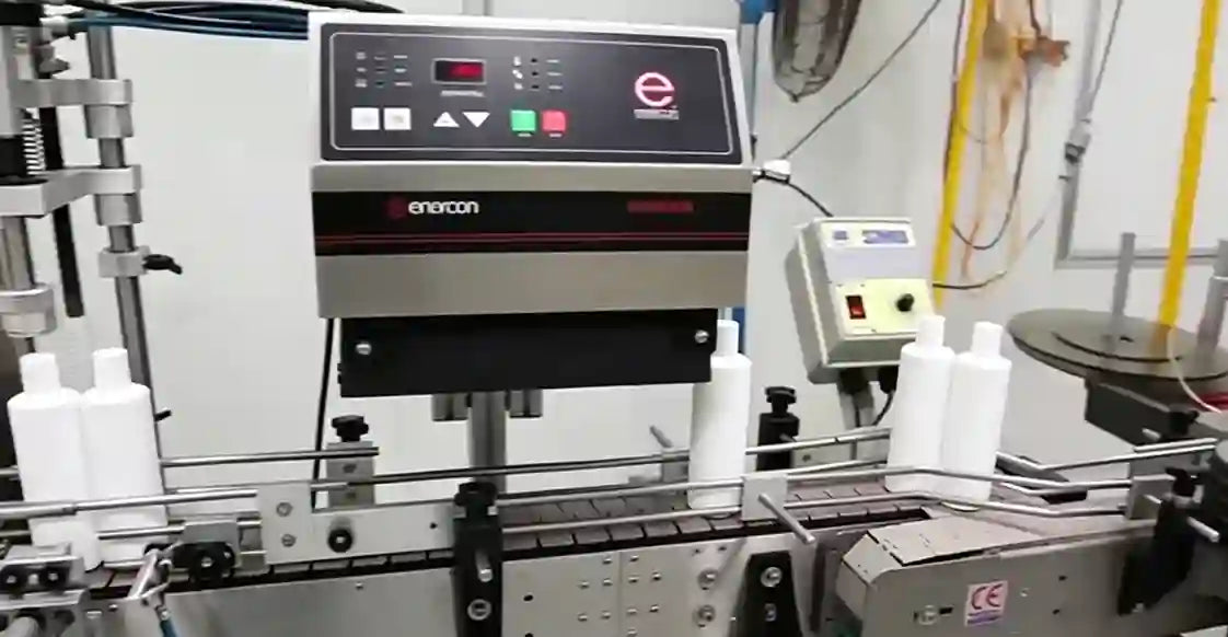 Automated ph scale balance machine with bottles on a production line 
