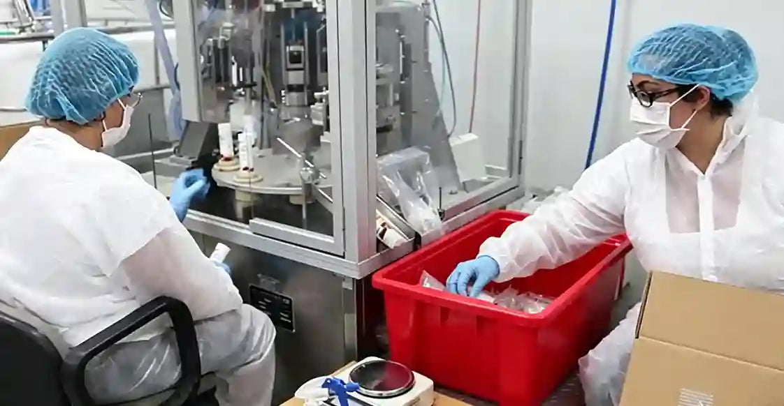 the arousellube lab Two scientists in a laboratory setting, one working with a machine and the other with a red container.