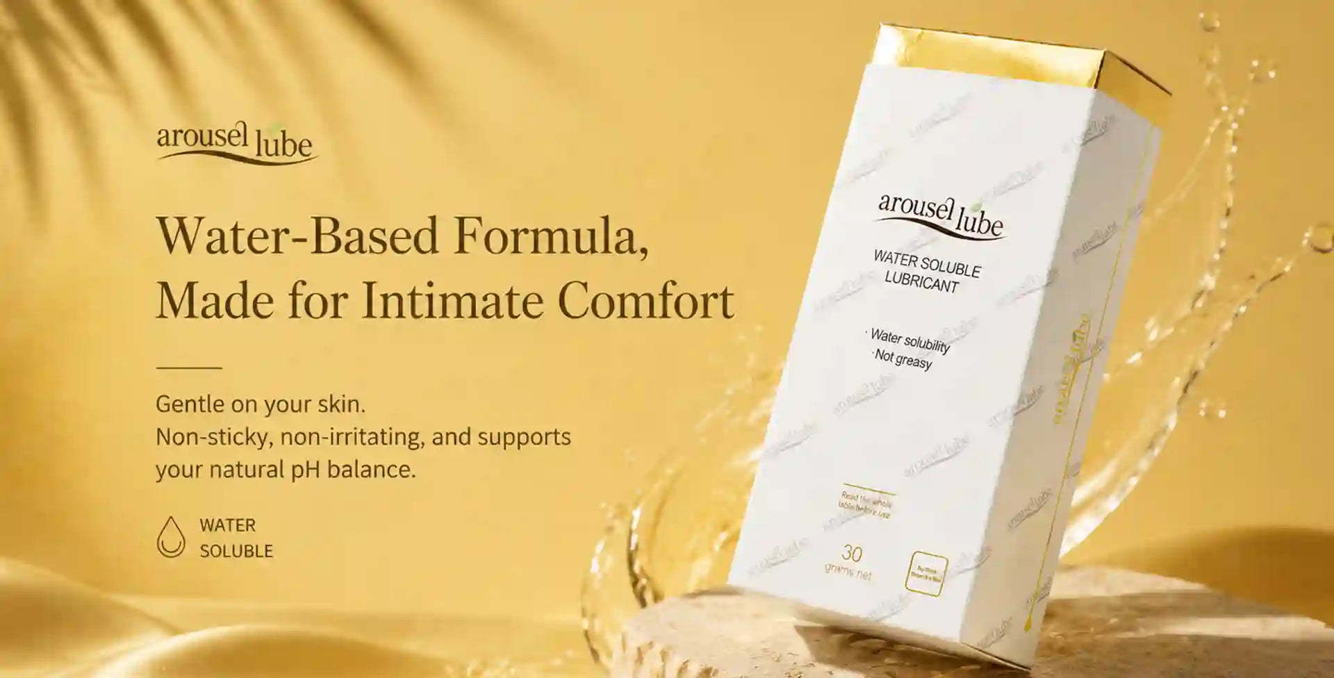Arousellube water-based intimate lubricant shown with its white and gold product box on a warm gold background with decorative liquid splash elements.