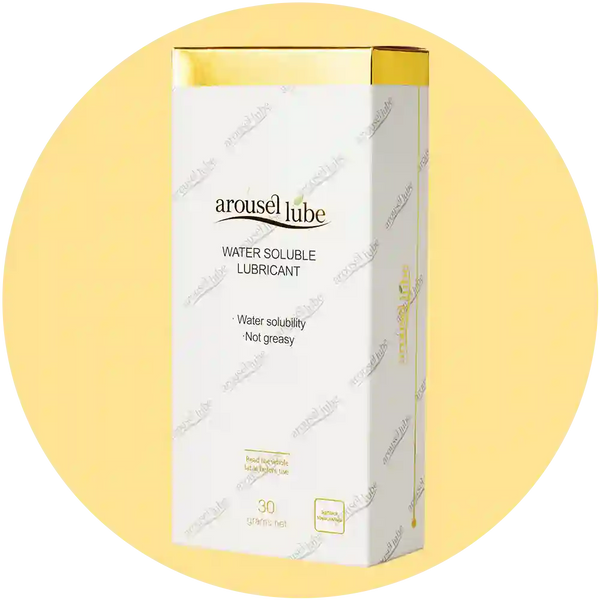 Aurousel Lube Water Soluble Lubricant box in white with gold accents, displayed on a pale yellow circular background.