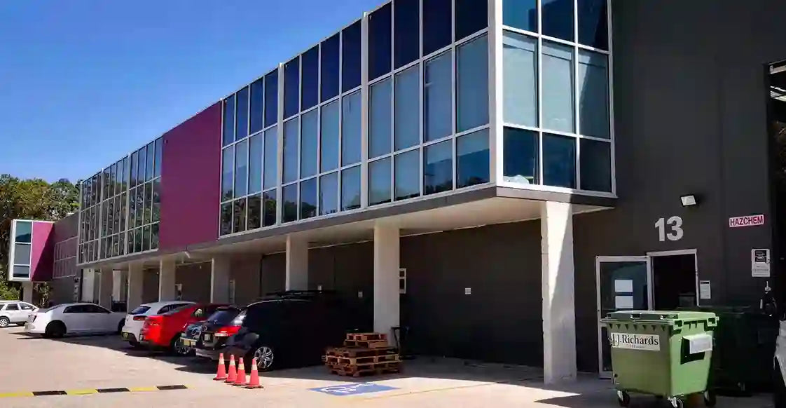 Modern building with glass facade and parking area on a clear day of aoursellube company 