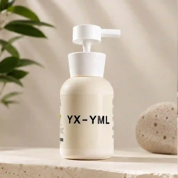 A cream-colored pump lube bottle with a white pump dispenser, featuring the text 'YX-YML' on the front, set on a stone surface with a blurred plant and decorative stone in the background.