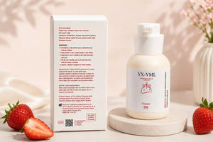A personal lube bottle labeled YX-YML stands on a round pedestal next to its product box, styled with fresh strawberries on a soft beige background.