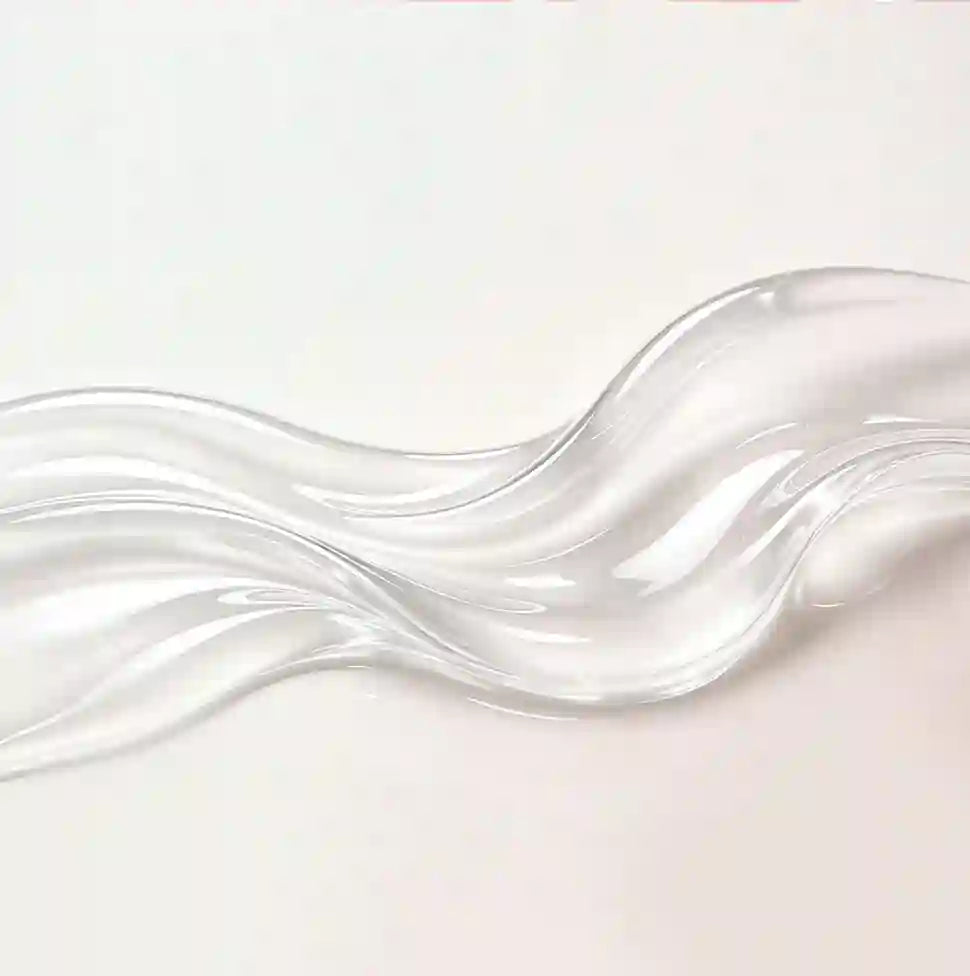 A translucent, wavy strip of clear material, resembling a glass or acrylic ribbon, displayed on a clean white background.